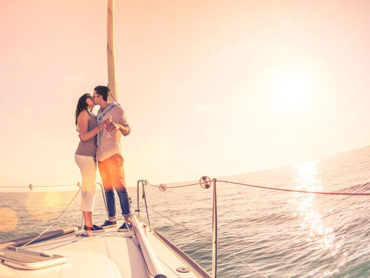 sunset couple kissing on sailboat