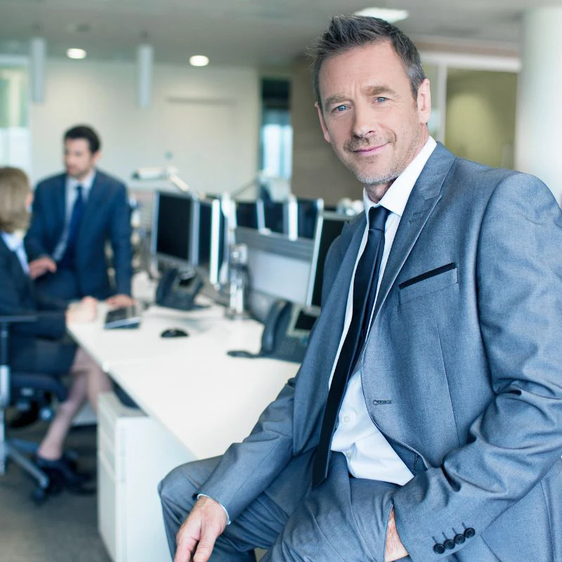 executive coach client sitting on desk in suit